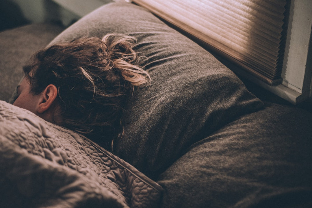 Person resting peacefully in bed illustrating deep sleep and recovery